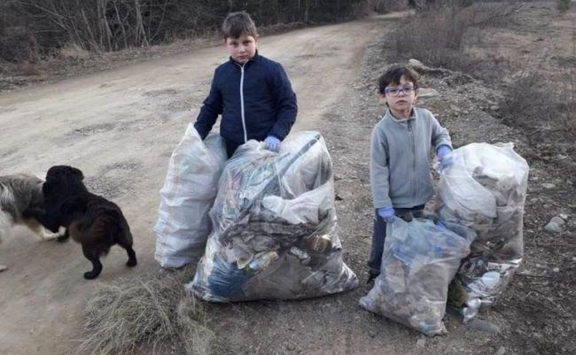 Doi copii au adunat toate gunoaiele de pe marginea drumului pe care merg spre scoala