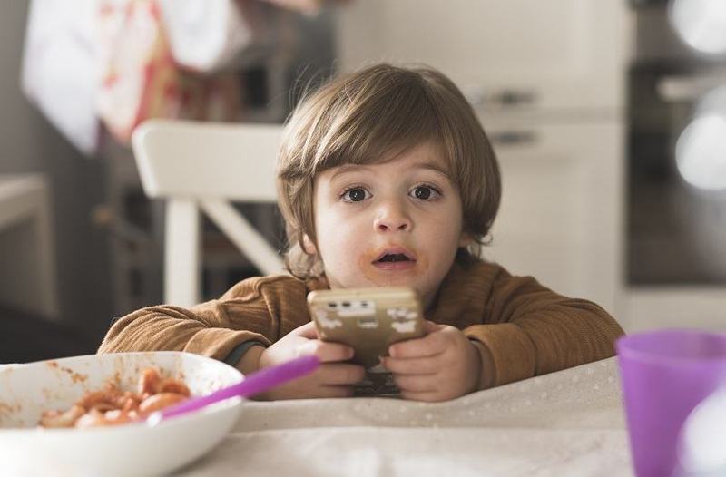 Copilul mananca doar cu telefonul? Cum il ajuti sa renunte la ecrane la masa