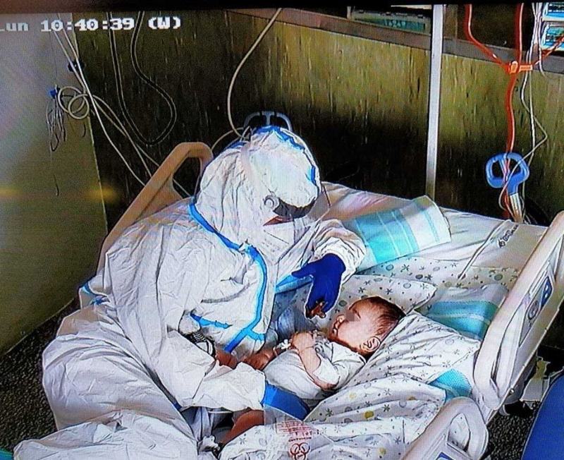 Imaginea umanitatii: O asistenta imbratiseaza un bebelus cu complicatii COVID, separat de mama